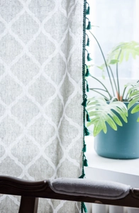 Close-up of green tassel fringe details on a geometric printed linen cotton curtain