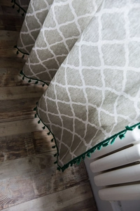 Detailed texture of cotton linen curtain with green geometric pattern and tassel trim