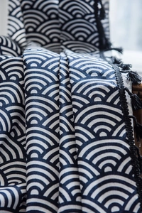 Close-up of navy Seigaiha wave pattern fabric with black fringe tassels on cotton linen