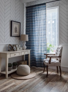 Detail of blue geometric bohemian cotton linen curtain with elegant beige tassels