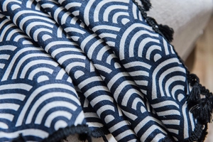Detailed close-up of navy Seigaiha wave pattern cotton linen fabric with black tassel fringe
