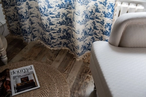 Detail of blue Toile de Jouy printed cotton linen curtain with elegant beige tassel fringe