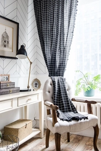 Detail of black and white checkered cotton linen curtain with decorative fringe