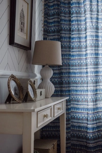 Detail of bohemian geometric pattern curtain with beige tassel trim on cotton linen fabric
