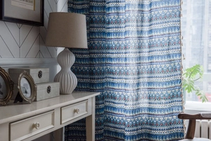 Detail view of blue geometric bohemian curtains showing fabric texture in cozy home setting