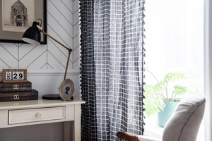 Detail of black and white checkered cotton linen curtain with black fringe tassels