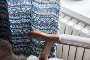 Detail of bohemian geometric print curtain with cotton linen texture and cream tassels