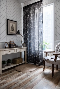Detail of black marble print curtain with elegant tassel fringe and linen texture