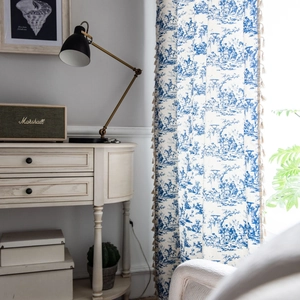 Blue toile cotton linen curtain with tassel trim in a vintage rustic interior setting