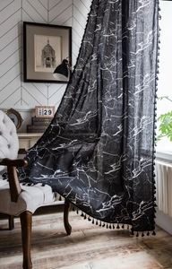 Detail of black marble print curtain with elegant tassels in a modern living room