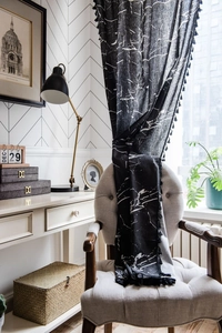 Detail of black marble print cotton linen curtain with decorative fringe ball tassels