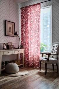 Detail of red Baroque floral print cotton linen curtains hanging in a bright study
