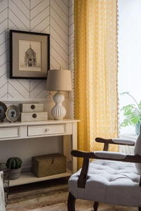 Detail of yellow geometric pattern curtain with beige decorative tassels for windows