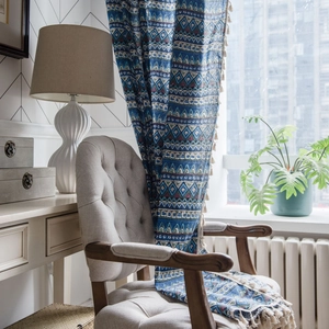 Blue geometric bohemian window curtain with elegant tassels in a cozy home interior setting
