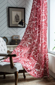 Close-up of red baroque pattern on cotton linen curtain draped over a white chair