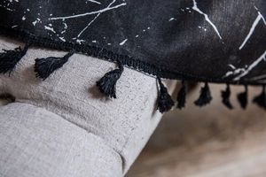 Detail of black marble print curtain with textured linen fabric and cotton fringe tassels