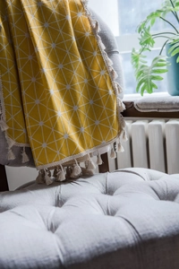 Close-up of yellow and white geometric pattern curtain with delicate fringe tassels