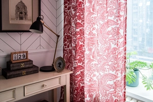 Detail of red Baroque floral print cotton linen curtain in a cozy home office setting