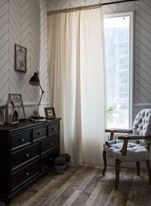 Close-up of cream semi-sheer lace curtains with elegant linen texture and soft draping