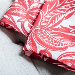 Detail of red tropical leaf print on cotton-linen fabric with stitching craftsmanship