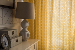 Detail of yellow geometric pattern curtain with cotton-linen texture in a cozy home setting