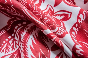 Macro shot of red and white floral cotton linen fabric with baroque twill weave pattern