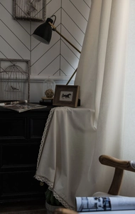 Detail of off-white linen fabric with elegant white lace trim on a vintage drawer