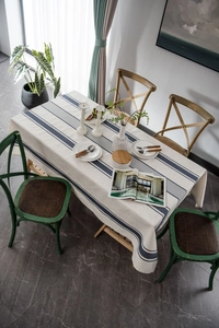Close-up of beige linen tablecloth with blue stripes and rustic woven texture