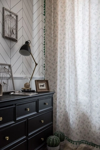 Detail of floral curtain with green tassel trim and elegant vintage home decor