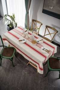 Detailed top view of red striped cotton linen tablecloth on a wooden dining table
