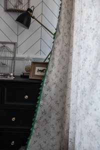 Detail of floral printed cotton linen curtain featuring elegant green fringe tassels decoration
