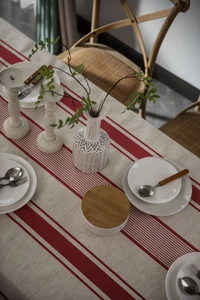 Close-up of red and white striped linen tablecloth with rustic tableware and decor