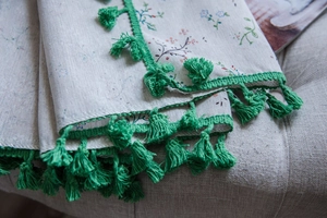 Close-up of floral print fabric texture with vibrant green tassel fringe edges