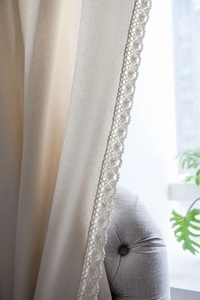 Close-up of cream cotton linen curtain featuring elegant crochet lace border trim