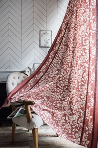 Dettaglio della tenda con stampa di fiori e uccelli drappeggiata su sedia vintage