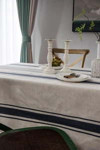 Detailed texture of cotton linen tablecloth with navy blue stripes on cream base