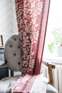 Dettaglio della tenda in cotone e lino arancione con motivi eleganti di uccelli e fiori