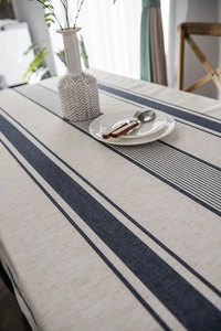Detail of blue striped cotton linen tablecloth with natural texture and neat edges