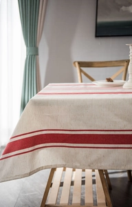 Detailed texture of beige cotton linen tablecloth with elegant red stripes on wood table