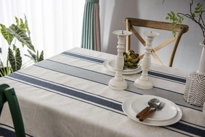 Detailed texture of beige linen tablecloth with blue stripes in a cozy dining setting