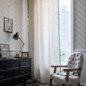Green tassel semi-sheer curtain with floral print in a cozy Nordic living room scene