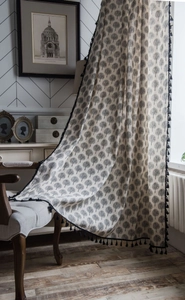 Detail of cotton linen curtain with black tree pattern and decorative tassel trim