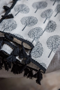 Detailed close-up of small tree print on linen cafe curtain with black tassel edge trim