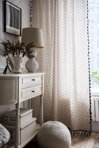 Detail of Nordic cotton linen curtain featuring daisy print and black tassel trim decor