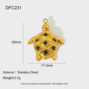 Detail of a golden sea turtle charm with 6 green gems and product size measurements