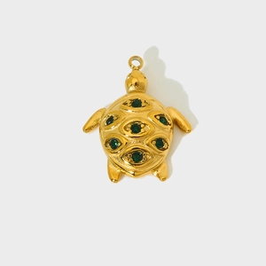 Golden sea turtle pendant with green crystal shell in a minimalist evil eye design