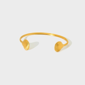 Vue détaillée du bracelet jonc ouvert en acier doré 18k avec motifs de coquille de mer