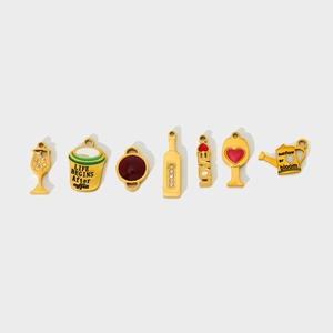Close-up of golden wine glass and bottle pendants with cubic zirconia and red enamel inlay