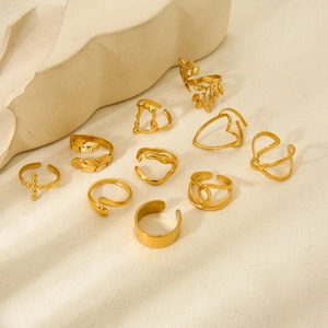 Set of 10 gold plated stainless steel leaf and geometric rings on aesthetic background
