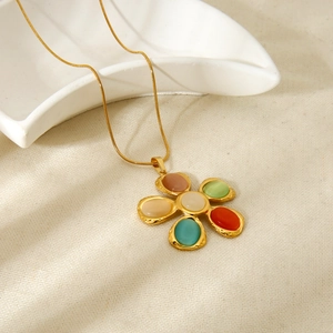 Primer plano detallado de un collar de flores chapado en oro de 18K con piedras ojo de gato